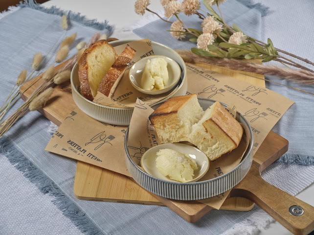 Warm house milk bread with whipped Vermont butter served in ceramic bowls at Prettiplatters